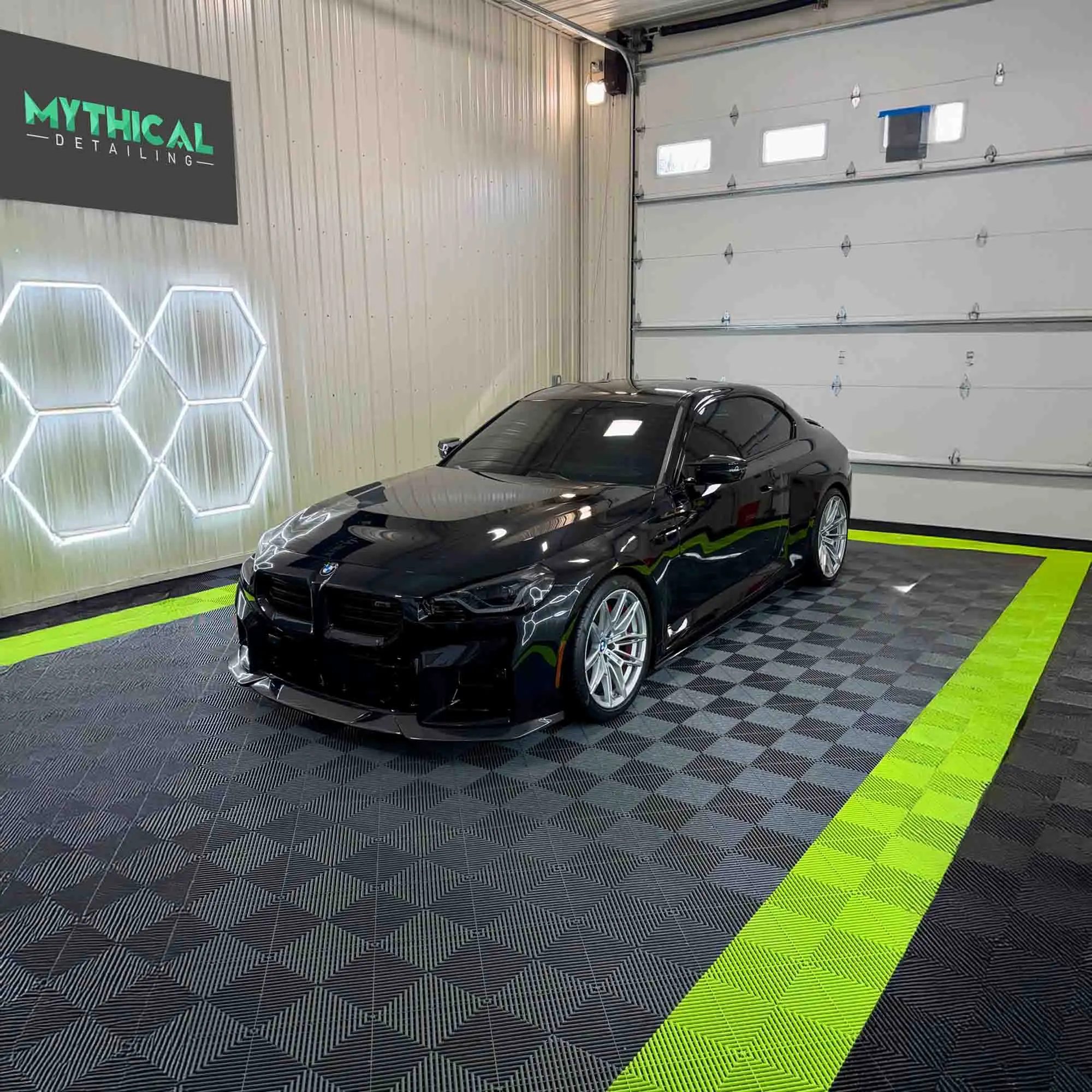 Black BMW with mirror-finish paint after machine polish at Mythical Detailing studio